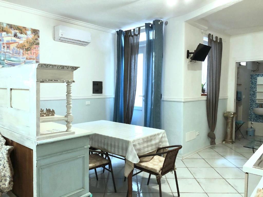 a dining room with a white table and chairs at TAVERNETTA SUL PORTO in Ischia