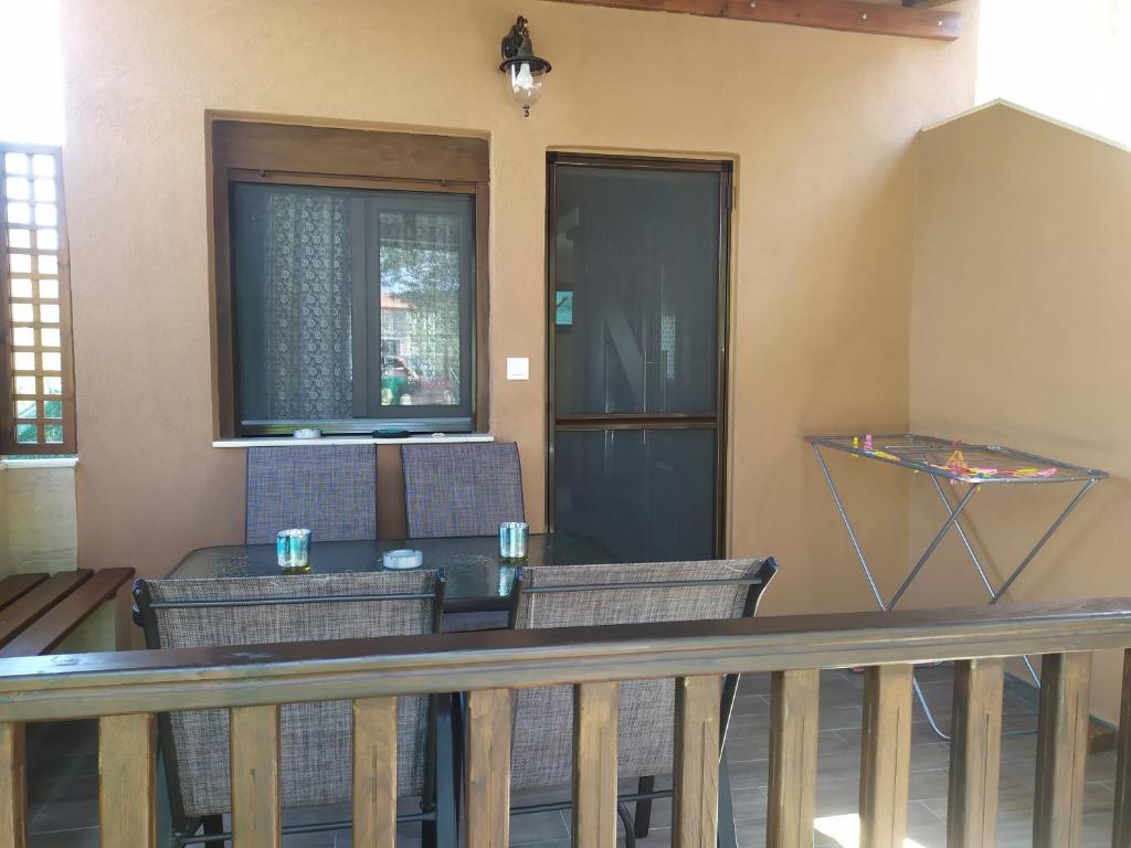 una veranda con sedie, tavolo e porta di Ioannis Stagkonis House 2 a Ormos Panagias