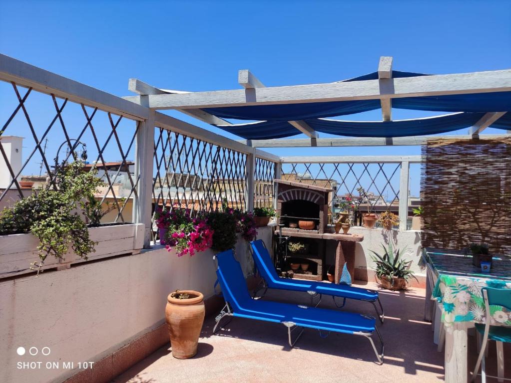 einen blauen Stuhl auf einem Balkon mit Kamin in der Unterkunft Sicilia Bedda Appartament in Bagheria