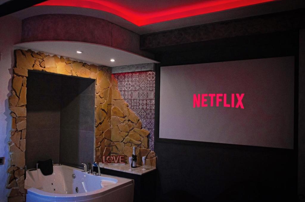 een badkamer met een netflix-bord op de muur bij Aparta suite la nuit in Calafell