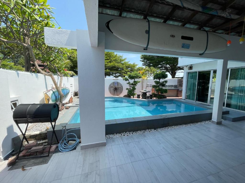 a house with a swimming pool with a surfboard on it at My Beach Villa in Port Dickson