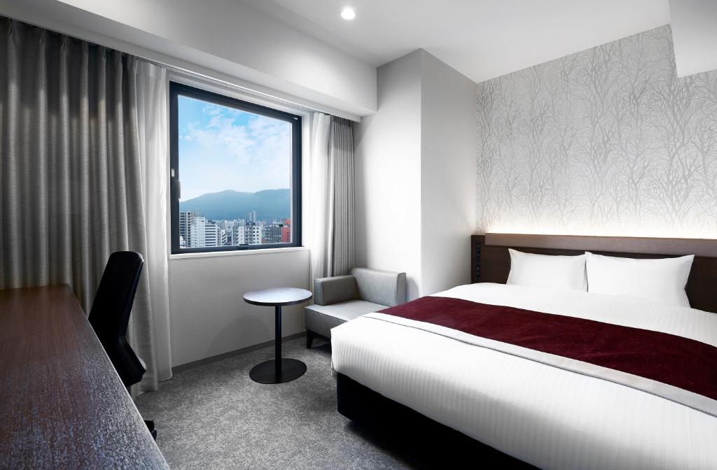 Postel nebo postele na pokoji v ubytování Daiwa Roynet Hotel Sapporo Nakajima Koen
