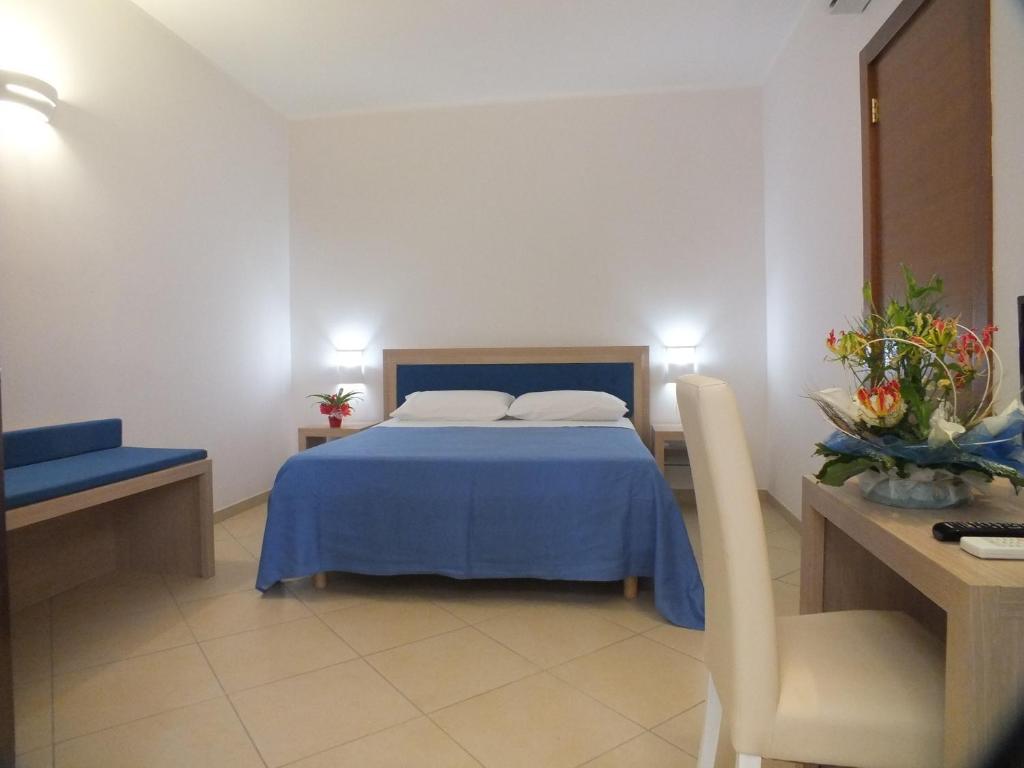 a bedroom with a blue bed and a desk at Agriturismo L'Angela in Borgagne