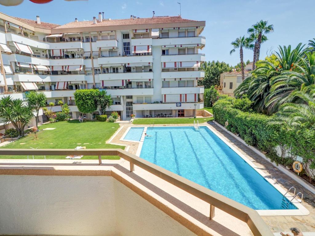an apartment with a swimming pool in front of a building at Clarimar Beach Apartment by Hello Homes Sitges in Sitges