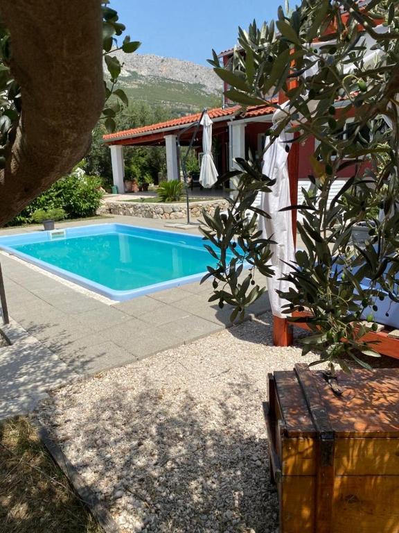 a swimming pool in front of a house at Villa D`Amante in Klis