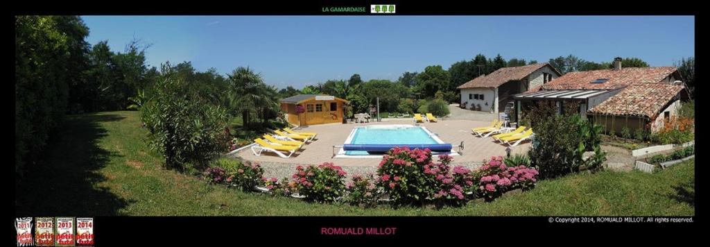 una piscina con tumbonas amarillas y una casa en La Gamardaise - M.Millot, en Gamarde-les-Bains