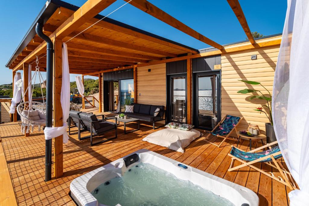 uma banheira de hidromassagem no deque de uma casa em Island of Heron - Bella Vista em Drage