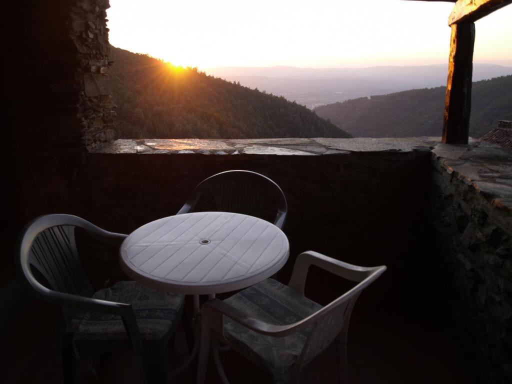 un tavolo e sedie con il tramonto sullo sfondo di Casa Lausus a Lousã