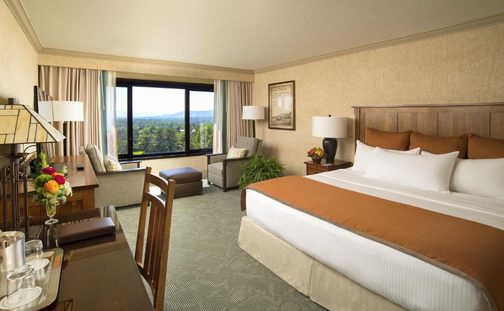 a hotel room with a large bed and a desk at The Omni Grove Park Inn & Spa - Asheville in Asheville