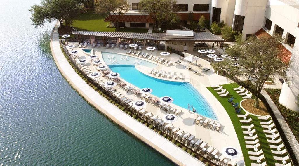Omni Las Colinas Hotel في ايرفينغ: اطلالة جوية على مسبح في منتجع