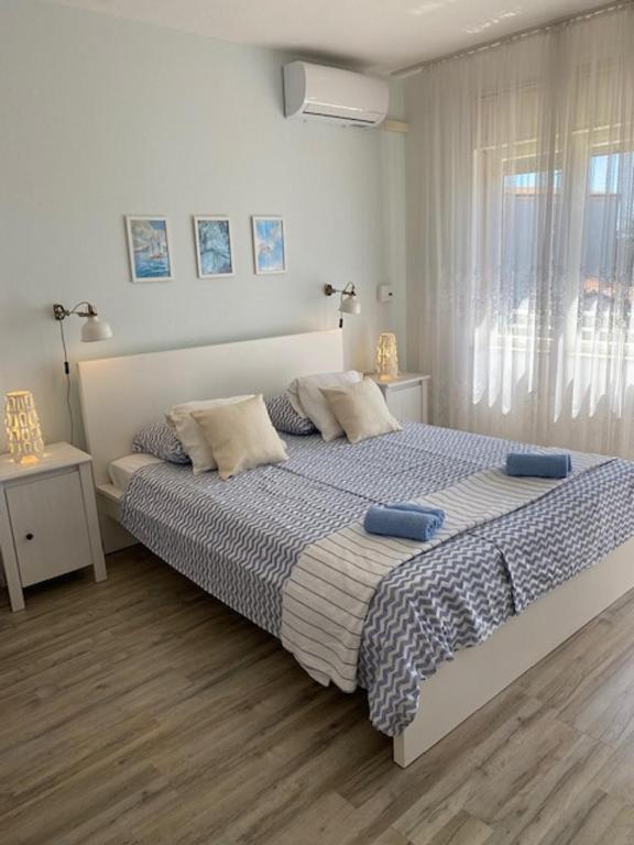 a bedroom with a large bed with blue pillows at Kosovic Family House in Medulin