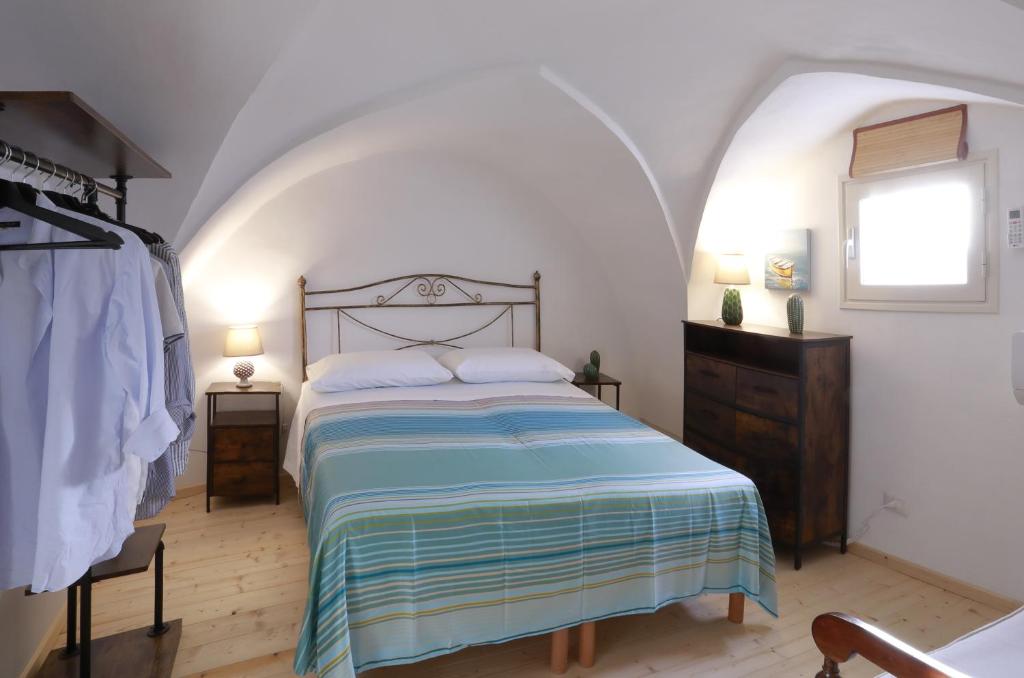1 dormitorio con 1 cama con manta azul y blanca en LaVí - Splendido appartamento sul mare, en Nardò