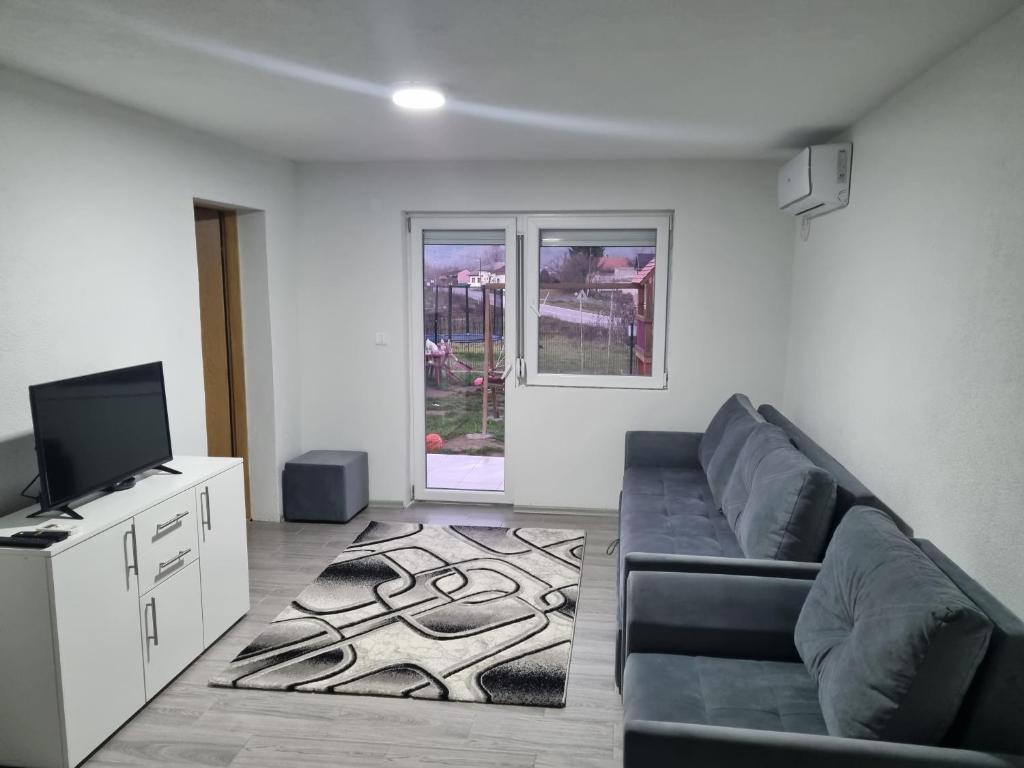 a living room with a couch and a flat screen tv at Apartman „Škobić” in Višegrad