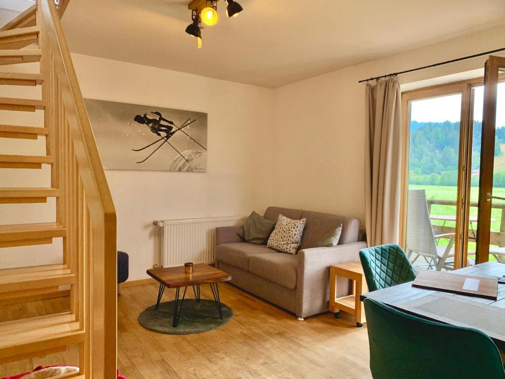ein Wohnzimmer mit Sofa und Tisch in der Unterkunft Alpenflair Ferienwohnung 231 Mina's Gipfelliebe in Oberstdorf