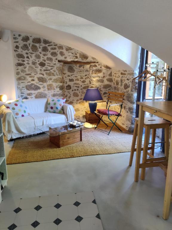 - un salon avec un canapé blanc et une table dans l'établissement Rendez-vous sous le tilleul, en Cevennes., à Molières-Cavaillac