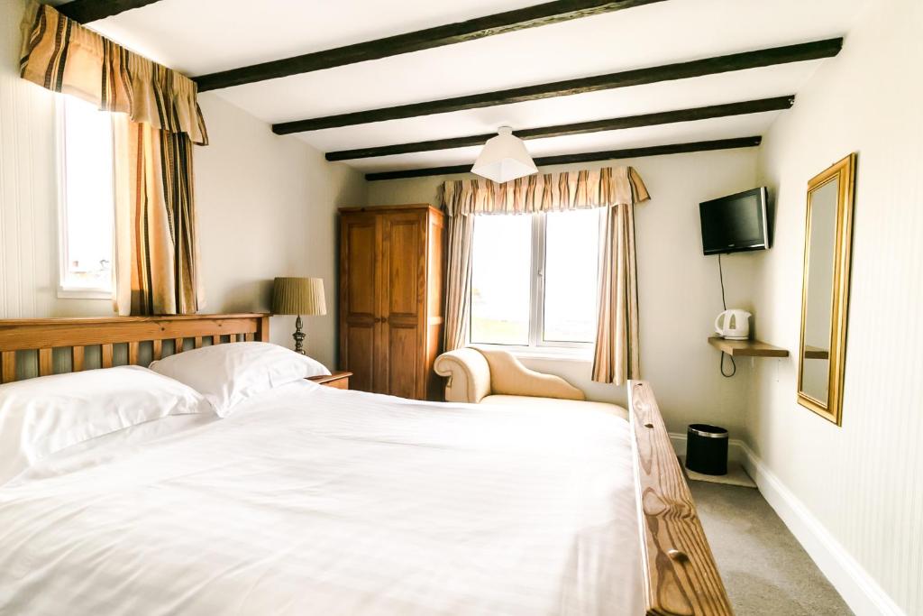 a bedroom with a white bed and a window at Raddicombe Lodge in Brixham