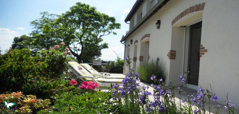 - un groupe de chaises assises à l'extérieur d'une maison fleurie dans l'établissement Le Domaine Augenaies Maison d hôtes et Spa, 