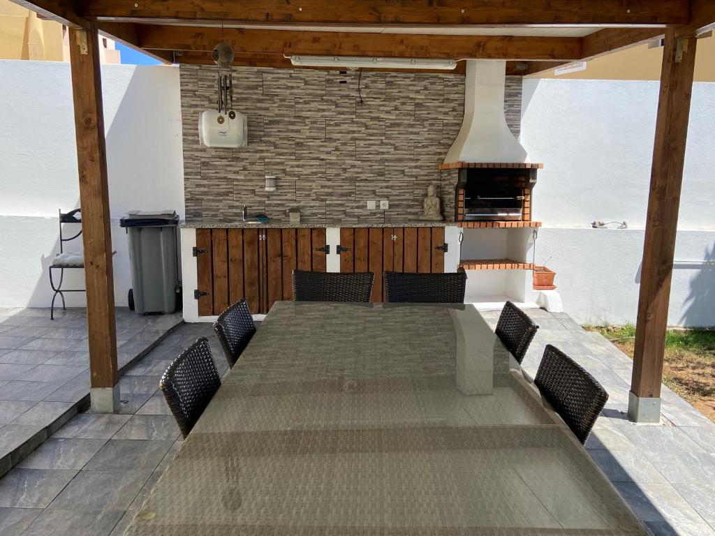 einen großen Holztisch mit Stühlen auf einer Terrasse in der Unterkunft Vivenda Sossego do Mar in Ferragudo