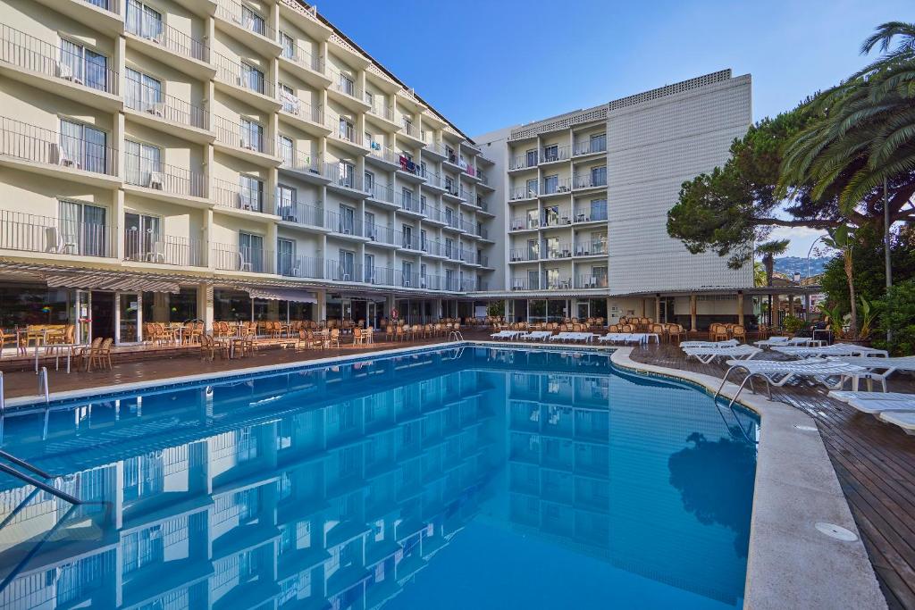 a swimming pool in front of a hotel at Don Juan Resort Affiliated by FERGUS in Lloret de Mar