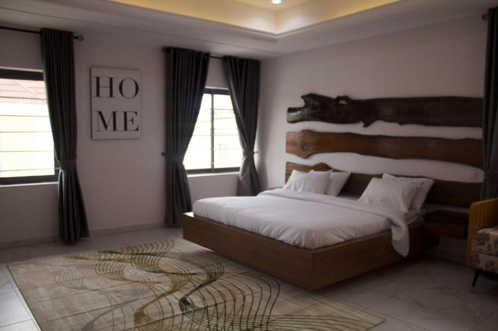 - une chambre avec un grand lit et une tête de lit en bois dans l'établissement The Bermondsey apartments, à Lagos