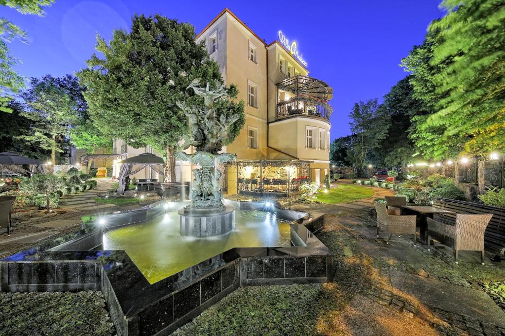 a mansion with a fountain in front of a building at Villa Meduza in Kołobrzeg