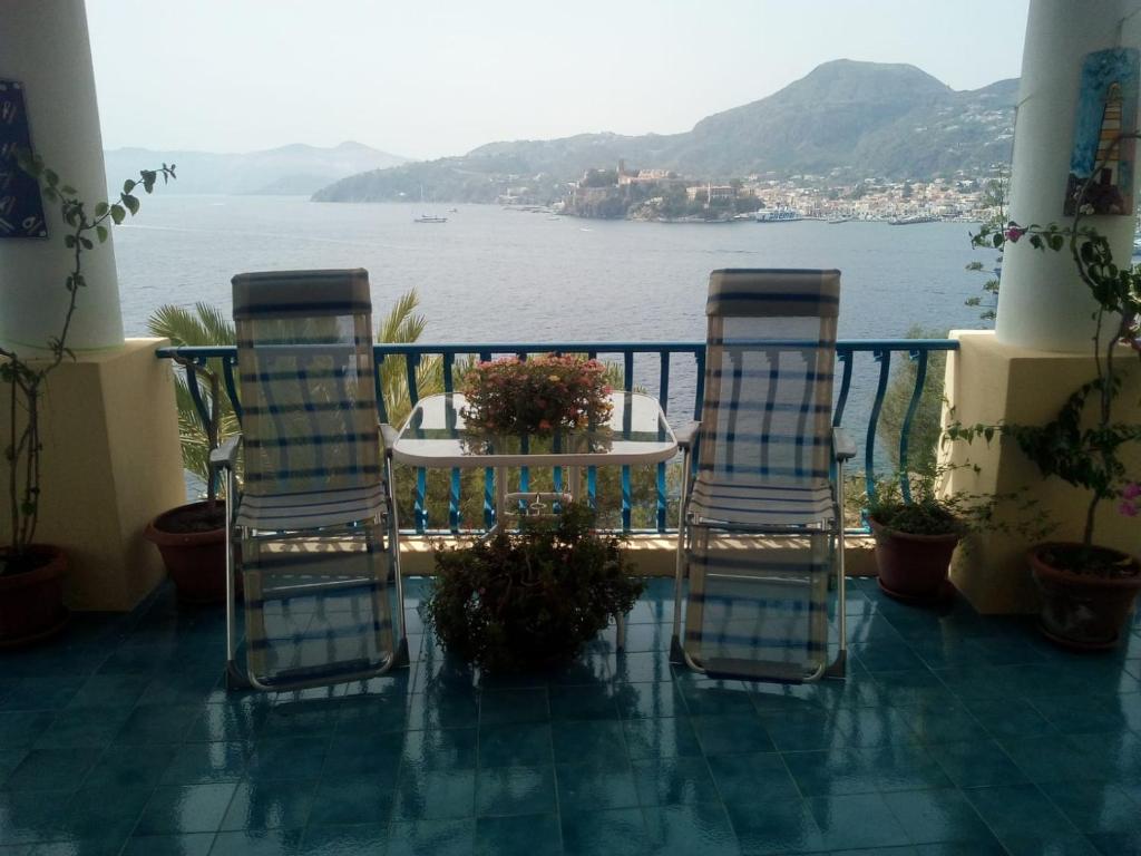 balcón con mesa, sillas y agua en La casa del Capitano, l'uomo e il mare ... en Lipari