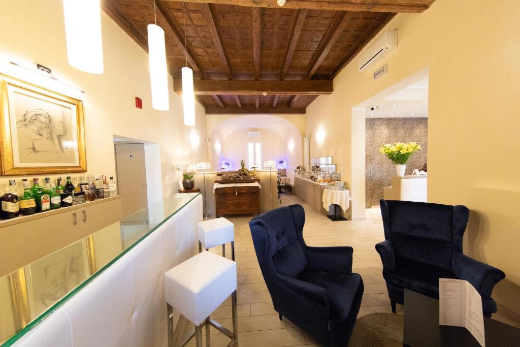 una sala degustazione con due sedie blu e un bar di Albergo Rossini 1936 a Bologna