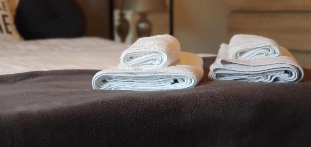 duas toalhas dobráveis sentadas em cima de uma cama em Struer Town Rooms em Struer