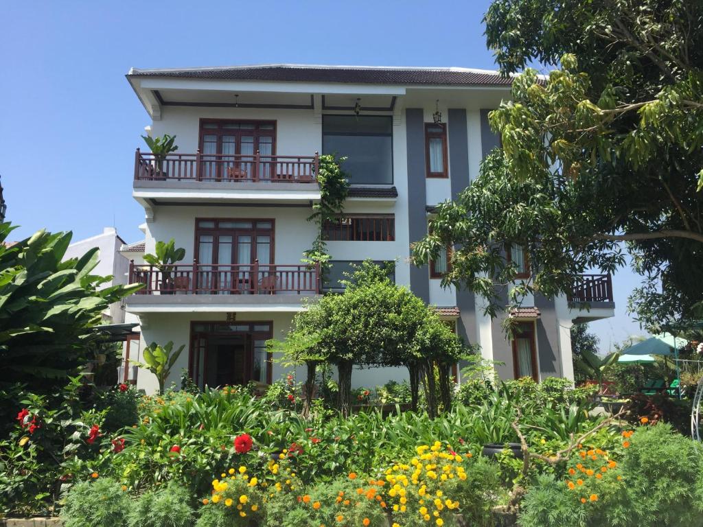 a building with flowers in front of it at Hoi an Osaka Riverside Villa & Spa in Hoi An