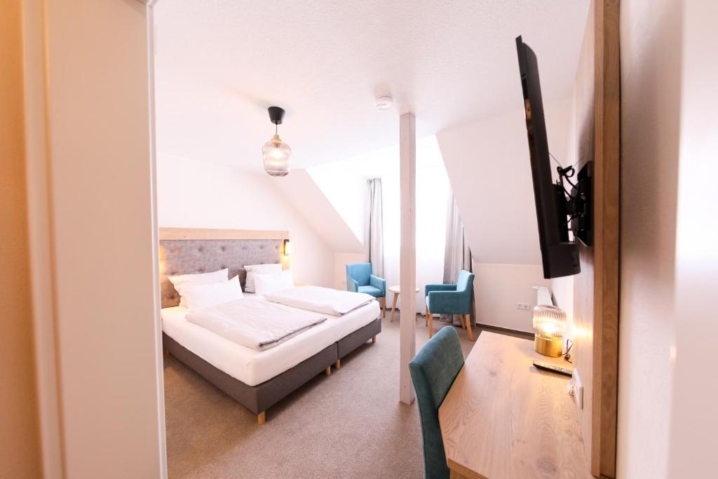 ein Schlafzimmer mit einem Bett und Stühlen in einem Zimmer in der Unterkunft 24/7 selfcheckin Schmiedestrasse in Leer