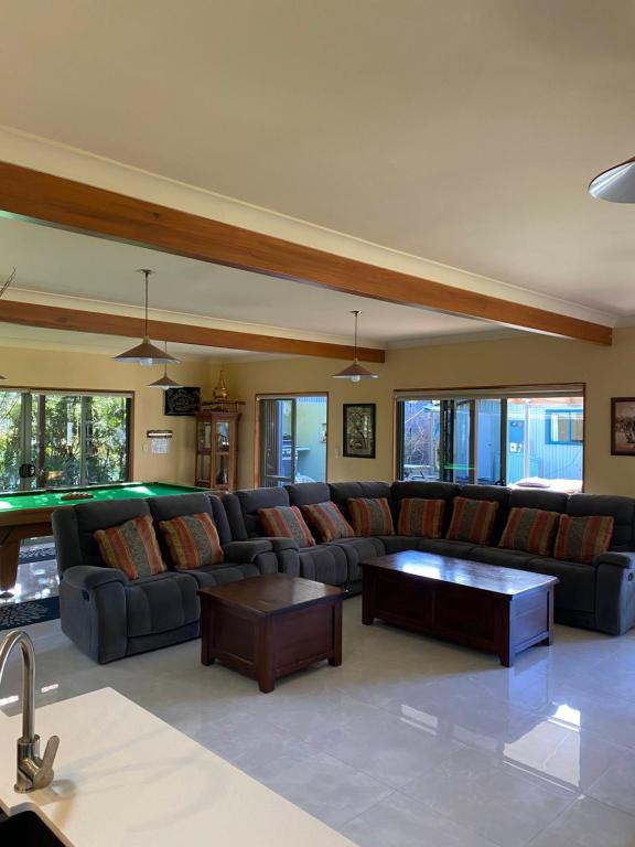 a living room with a couch and a pool table at Abel Tasman Marahau in Marahau