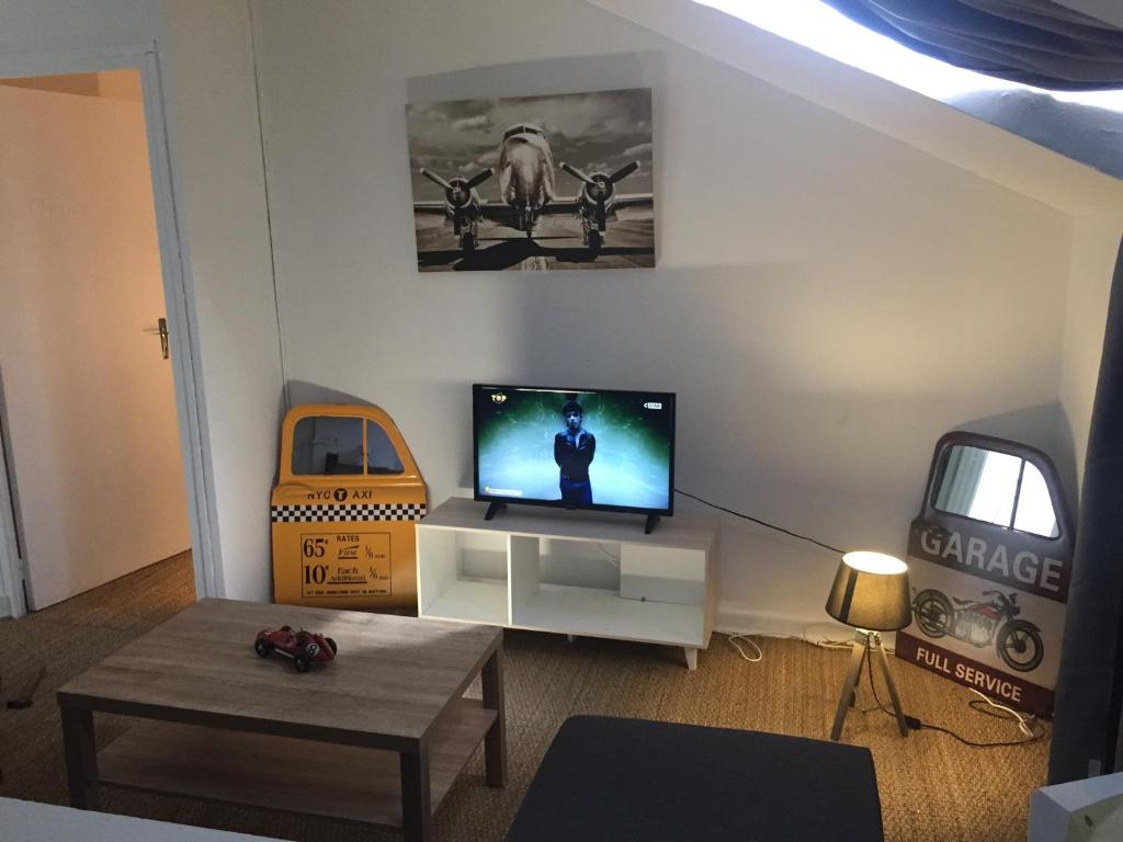 uma sala de estar com uma televisão de ecrã plano na parede em Victor Hugo 4 G et sa pizza offerte em Aurillac