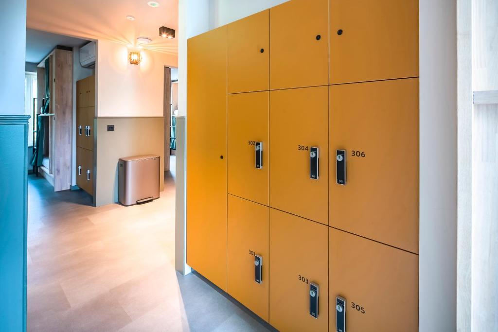 a locker room with yellow lockers in a room at The Bee Hostel in Amsterdam