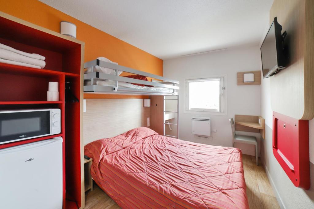 Habitación pequeña con cama y TV. en Premiere Classe Lyon Beynost, en Beynost
