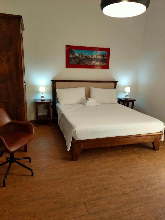 a bedroom with a bed and two tables and a chair at Family House in Lecce