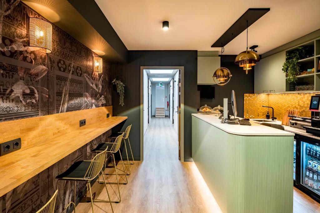 a bar in a restaurant with a counter and chairs at The Bee Hostel in Amsterdam