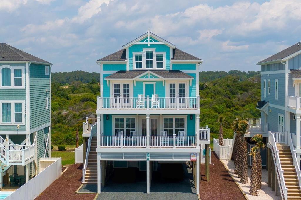a blue and white house with a balcony at Oceanview Reserve home in Holden Beach