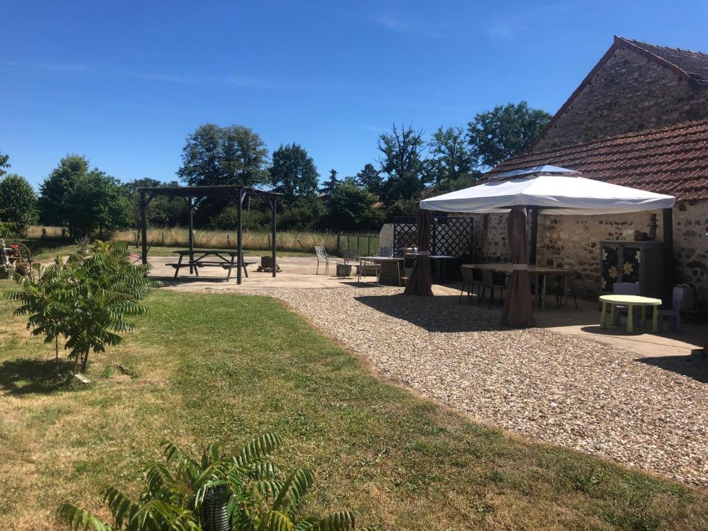 a picnic area with benches and an umbrella at 1 Bedroom Tranquil Cottage Fishing by the lake in Bommiers