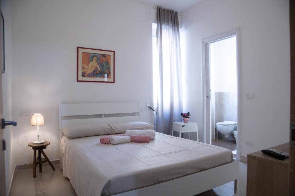 コンヴェルサーノにあるLa Vispa Teresa zona ospedaleの白いベッドルーム(ベッド1台、バスルーム付)