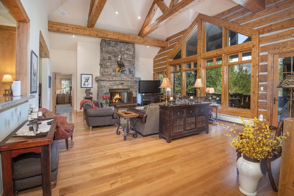 an open living room with a stone fireplace and wooden ceilings at 40 Goshawk home in Avon