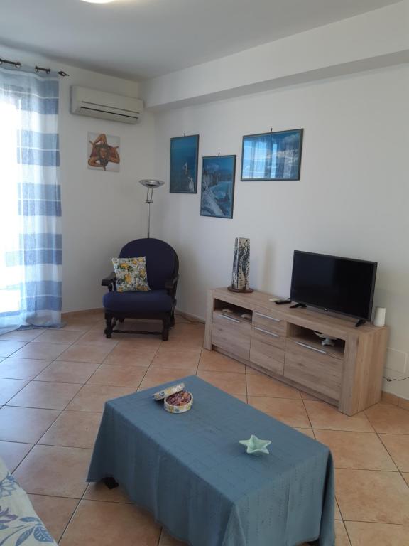 een woonkamer met een tafel en een televisie bij A casa di Loretta in Terrasini