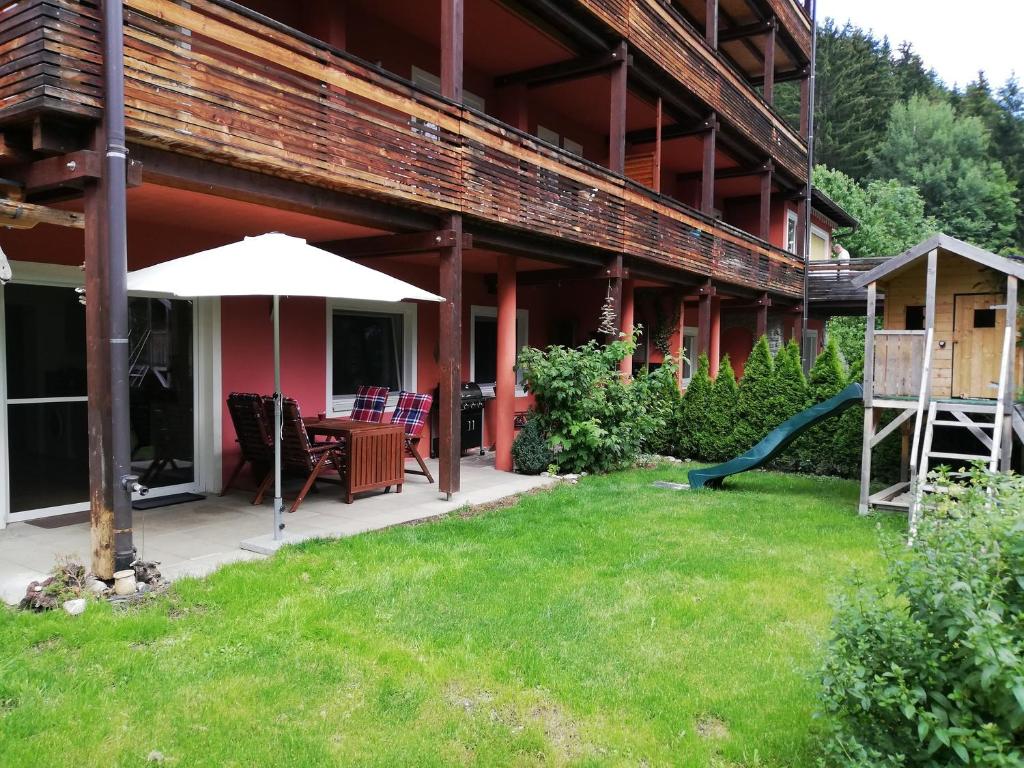 - une terrasse avec une table et un parasol dans la cour dans l'établissement Ferienwohnung Jonas, à Gödnach