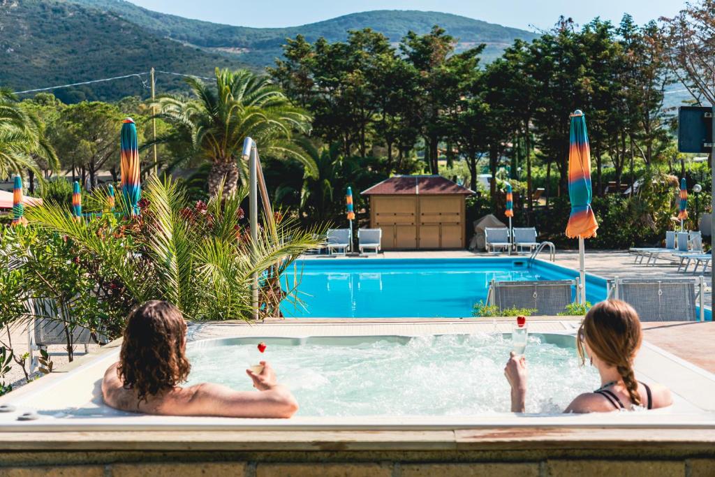 dos personas sentadas en una piscina en Casa Dei Prati Camping Village, en Lacona