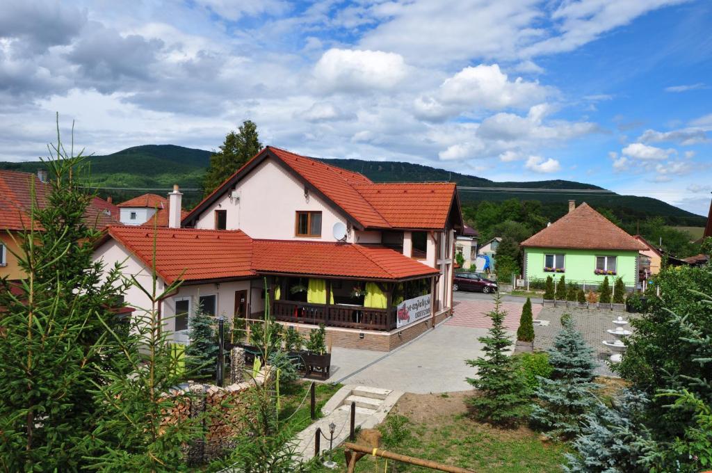 duży dom z czerwonym dachem w obiekcie András penzión w mieście Krásnohorské Podhradie