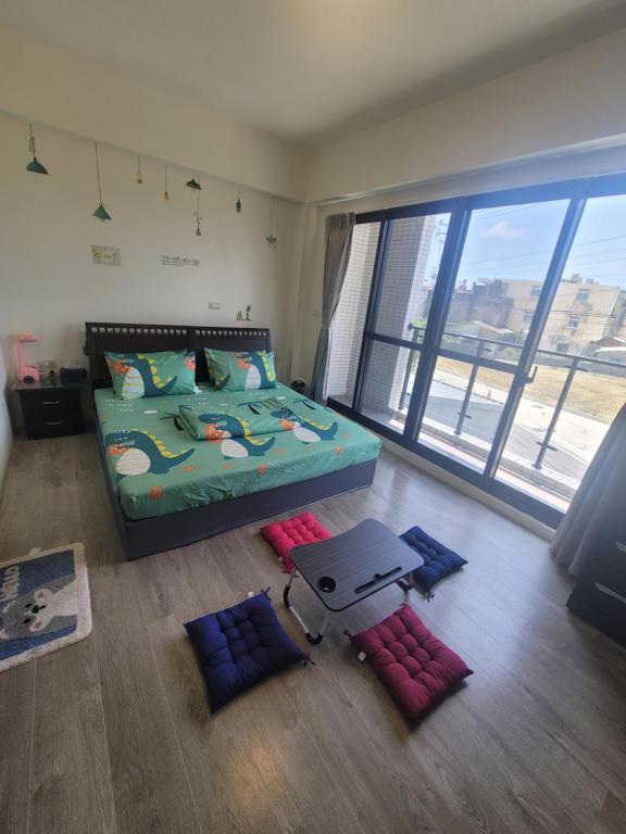 1 dormitorio con cama y ventana grande en Gaomei 607 Homestay, en Qingshui