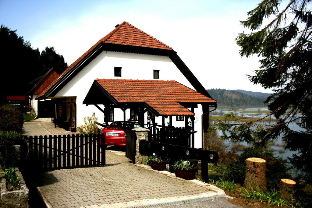 Casa blanca con techo rojo y valla en Apartment Šefic en Planina