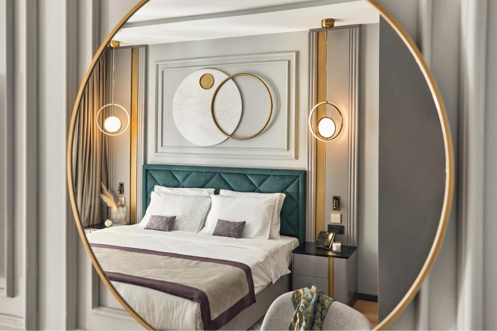 sypialnia z łóżkiem ze złotą ramą i lustrem w obiekcie La Fleur Boutique Hotel w mieście Tivat