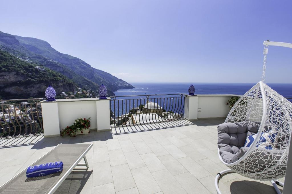a hammock sitting on a balcony overlooking the ocean at Estate4home - Villa Settemari Scrigno in Positano