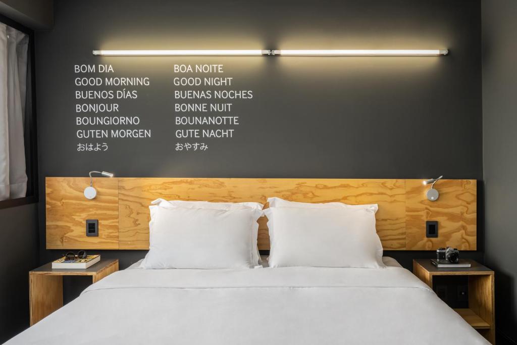 ein Schlafzimmer mit einem großen Bett und weißen Kissen in der Unterkunft Intercity Canoas in Canoas