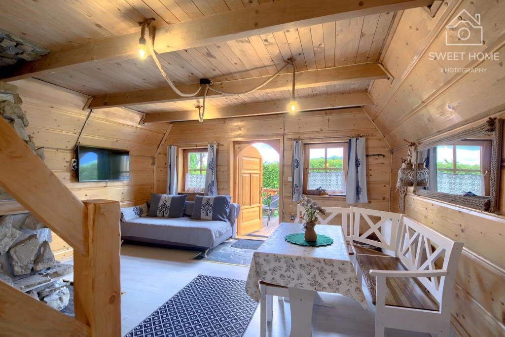 a log cabin living room with a couch and a tv at Oaza Tatry I in Zakopane